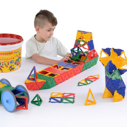 Nen jugant amb peces geomètriques Polydron de colors vius i plàstic, al costat del seu gran pot groc d'emmagatzematge.