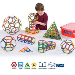 Nen jugant amb marcs geomètrics Polydron de colors vius, formant figures 3D al costat d'un contenidor de plàstic vermell.