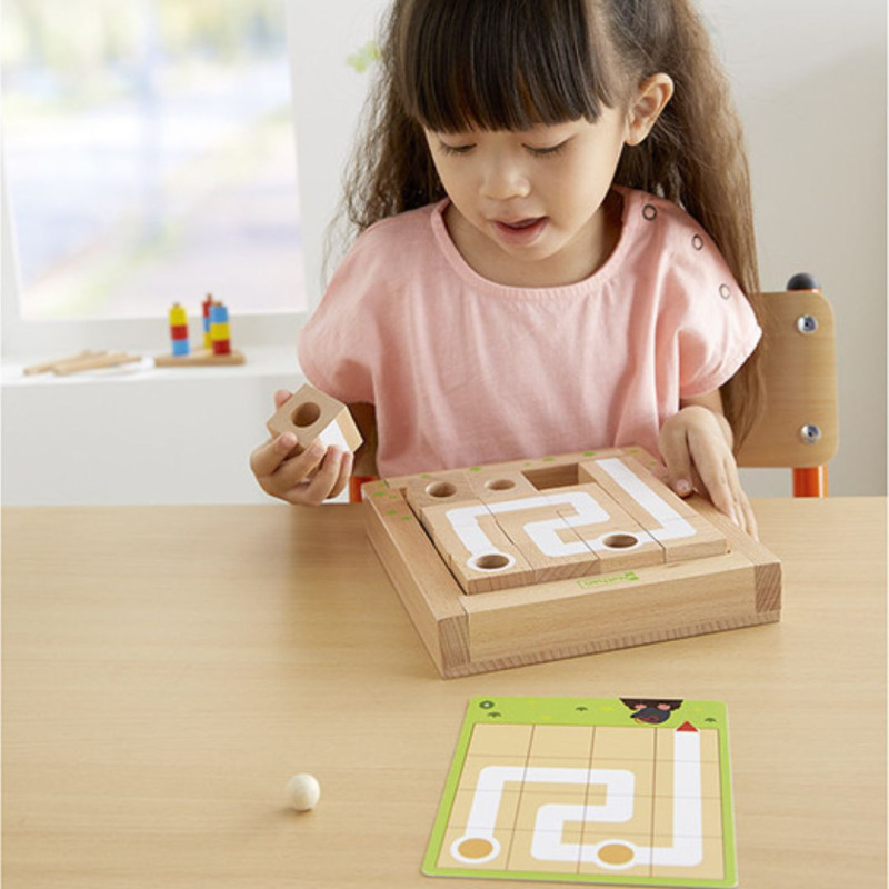 Labycubos de madera clara con tablero cuadrado, piezas cúbicas y tarjetas verdes de retos para aprender programación STEM.