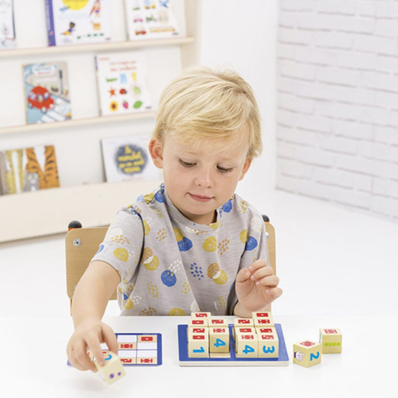 Nen jugant amb cubs de fusta numerats i acolorits sobre una base blava. Un trencaclosques educatiu per aprendre matemàtiques.