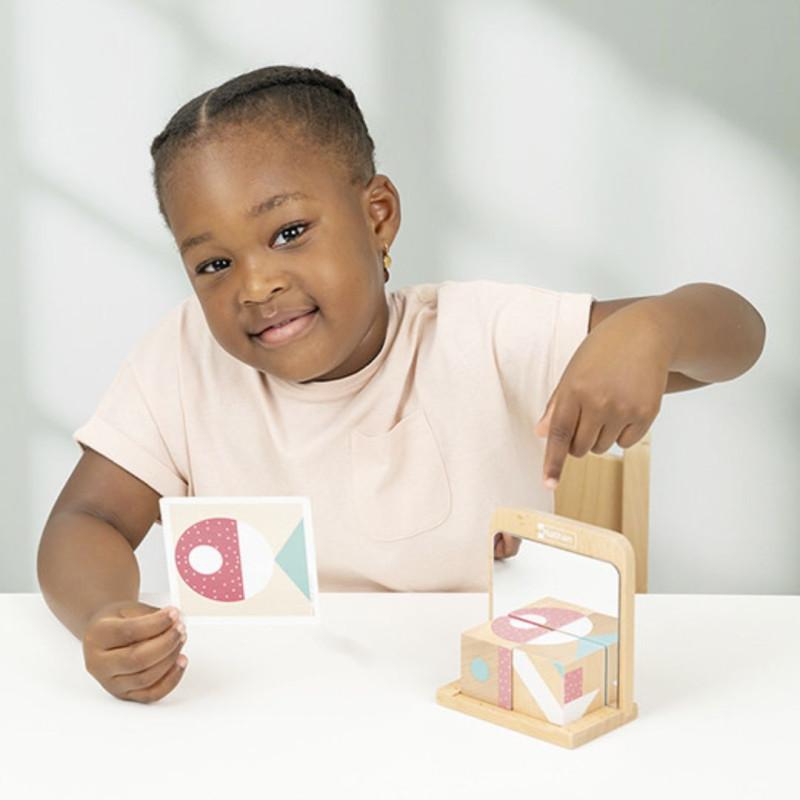 Bloques de madera en tonos pastel y espejos para recrear figuras geométricas siguiendo tarjetas de desafíos.