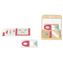 Espejo en soporte de madera junto a tarjetas con figuras geométricas en tonos rosa y verde para crear simetrías.