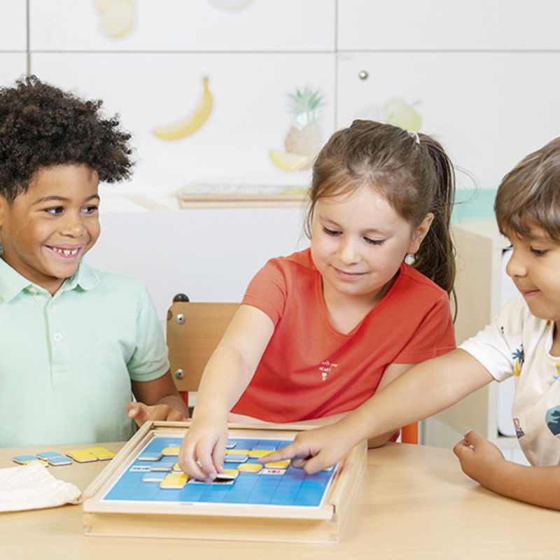 Niños usando el tablero de madera azul Pixel Challenge con piezas de colores para practicar el conteo y las cantidades.
