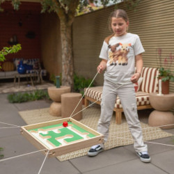 Laberinto cuadrado de madera con cuerdas, base verde y bola roja. Juego cooperativo para entrenar la coordinación y el equilibri