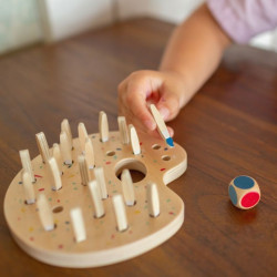 Tauler de fusta en forma de paleta amb petits pinzells de colors i un dau per entrenar la memòria i la coordinació.